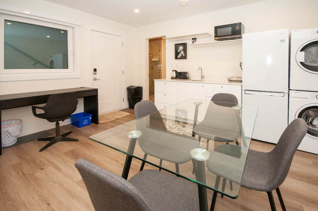 Bright kitchen with white countertops, hardwood floors, and a city view. - Suite 2 - 788 Montroyal Boulevard, North Vancouver
