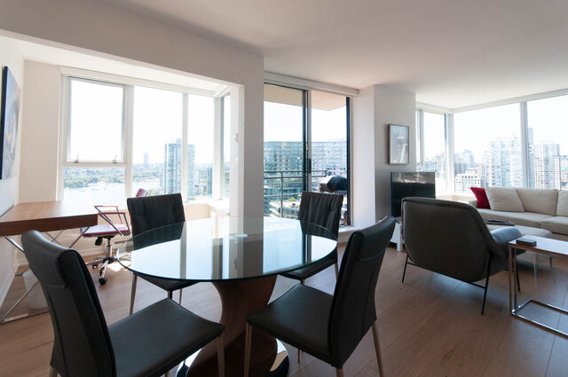 Spacious living room with hardwood floors, modern furniture, and stunning city views. - 3006 - 33 Smithe Street, Vancouver Downtown