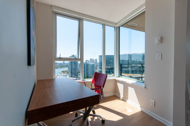 Spacious den with hardwood floors, a sleek desk, and a stunning city view. - 3006 - 33 Smithe Street, Vancouver Downtown