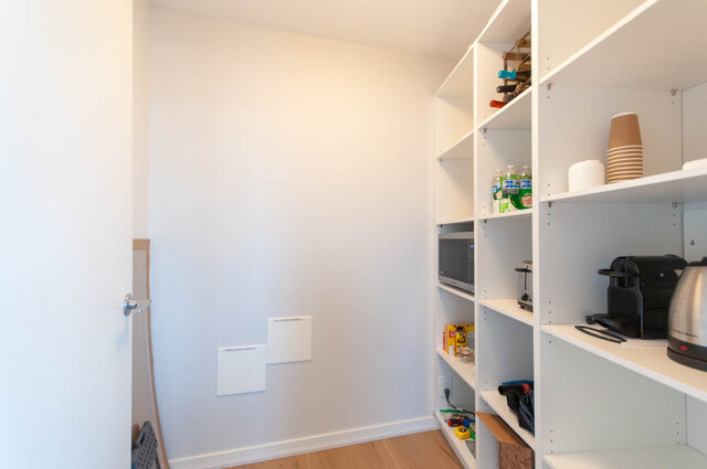 Bright kitchen with white shelving, hardwood floors, and modern appliances. - 3006 - 33 Smithe Street, Vancouver Downtown