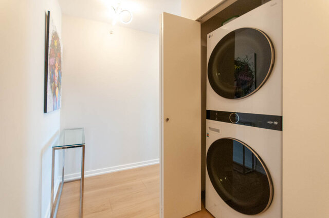 Bright laundry room with modern LG washer and dryer, hardwood floors, and a sleek countertop. - 3006 - 33 Smithe Street, Vancouver Downtown