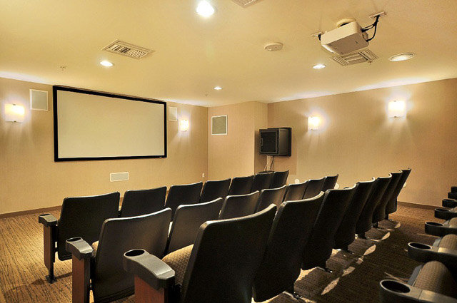 Spacious home theater with plush seating, a large blank screen, and ambient lighting. - 3006 - 33 Smithe Street, Vancouver Downtown