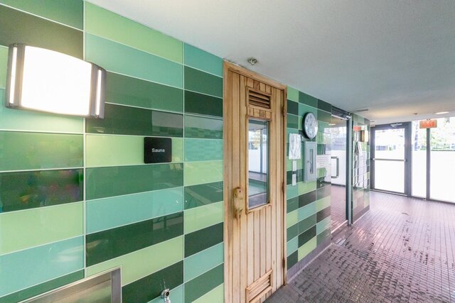 Spacious sauna with green tiles and wooden door, perfect for relaxation. - 3006 - 33 Smithe Street, Vancouver Downtown