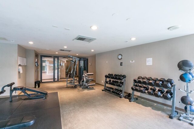 Spacious, well-equipped gym with dumbbells, exercise balls, and cardio machines. - 3006 - 33 Smithe Street, Vancouver Downtown