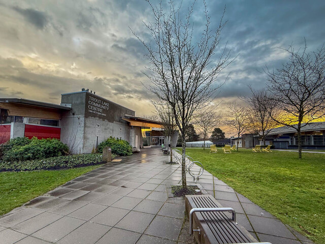 Spacious patio with modern furniture and community center in the background. - TH 13 - 2030 East 20th Ave, Vancouver East Side