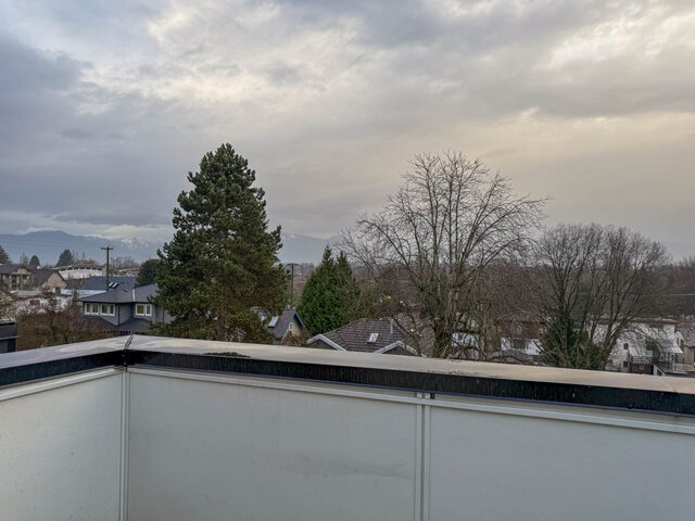 Bright balcony with city view and snow-capped mountains in the distance. - TH 13 - 2030 East 20th Ave, Vancouver East Side