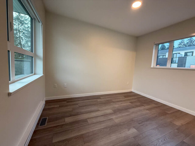 Spacious living room with hardwood floors and large windows, perfect for relaxation. - TH 13 - 2030 East 20th Ave, Vancouver East Side