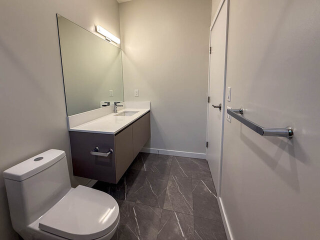 Modern bathroom with sleek vanity countertop and accessible grab bars. - TH 12 - 2030 East 20th Ave, Vancouver East Side