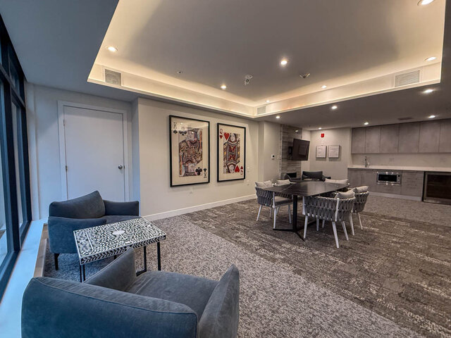 Spacious living room with modern decor, featuring a king and queen of hearts artwork and a cozy seating area.