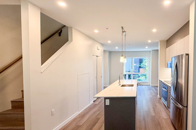Bright kitchen with white marble island, hardwood floors, and a city view. - TH 46- 2050 East 20th Ave, Vancouver East Side