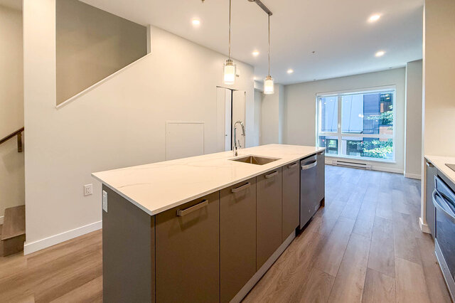 Modern kitchen with white marble countertops, hardwood floors, and a city view. - TH 46- 2050 East 20th Ave, Vancouver East Side