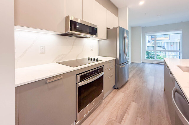 Bright kitchen with modern appliances, white marble countertops, and hardwood floors. - TH 46- 2050 East 20th Ave, Vancouver East Side