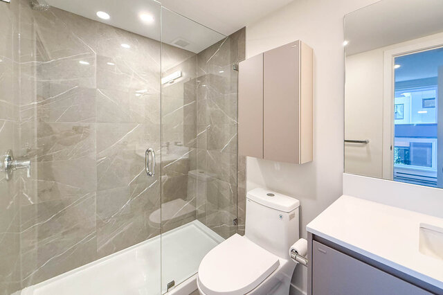 Modern bathroom with a large walk-in shower, sleek countertop, and a view of the city. - TH 46- 2050 East 20th Ave, Vancouver East Side