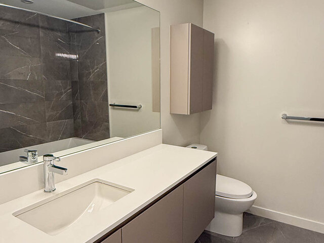 Bathroom with a long white vanity, a large mirror and a wall cabinet - 302-3588 Hull St, Vancouver East Side