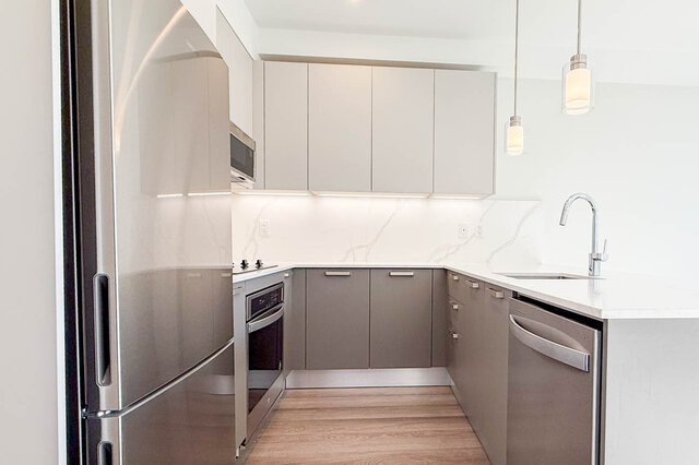 Bright kitchen with white marble countertops and stainless steel appliances. - 400 - 3588 Hull St, Vancouver East Side