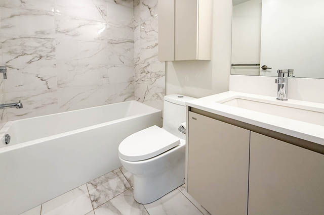 Furnished bathroom with marble walls and a modern sink. - G 22 - 2070 East 20th Ave, Vancouver East Side