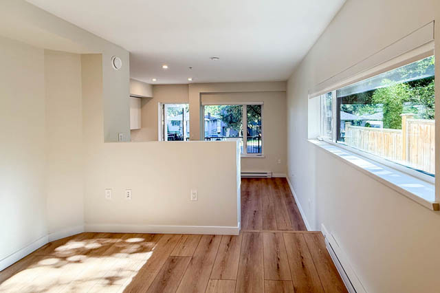 Bright living room with hardwood floors and large windows, letting in natural light. - G 22 - 2070 East 20th Ave, Vancouver East Side