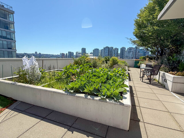 The balcony features concrete planters with greenery, outdoor seating, and a city skyline view. - 812-189 Keefer Street, Vancouver Downtown