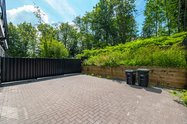 Furnished patio with brick paving and wooden planter boxes. - 1-4096 Nithsdale Street, Burnaby