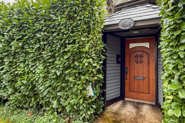 Spacious entryway with lush greenery and a warm wooden door, inviting you into a 4-bedroom furnished house on the West Side.