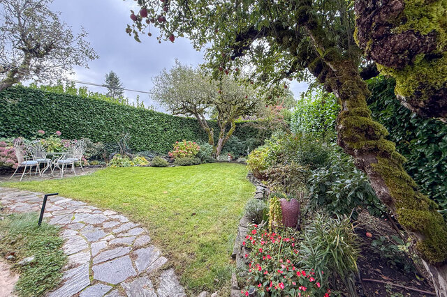 Spacious backyard with lush greenery, stone patio, and fruit-bearing trees. - 3850 Point Grey Road, Vancouver West Side