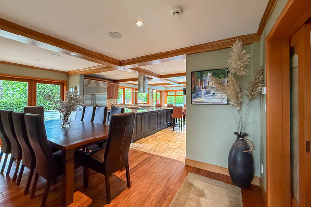 Spacious dining area with hardwood floors, modern kitchen, and large windows. - 3850 Point Grey Road, Vancouver West Side