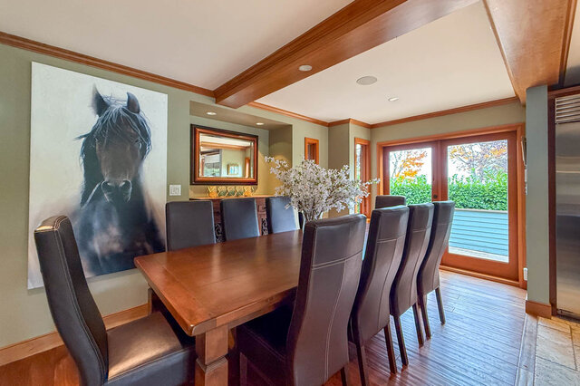 Elegant dining room with wooden table, leather chairs, horse mural, and garden view. - 3850 Point Grey Road, Vancouver West Side