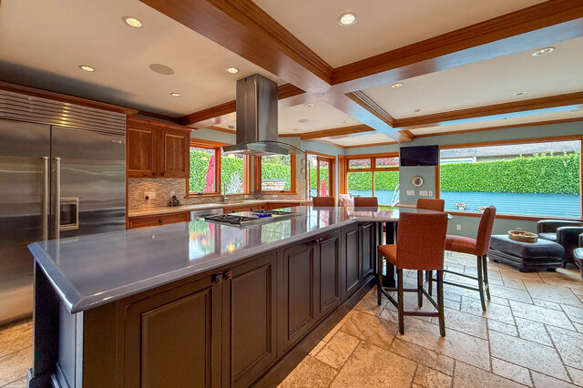 Spacious kitchen with granite countertops, wood cabinets, and a view of the backyard. - 3850 Point Grey Road, Vancouver West Side