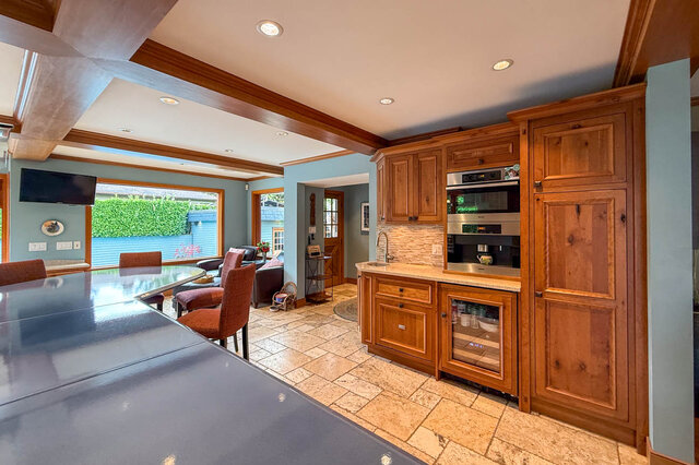 Bright kitchen with wooden cabinets, granite countertops, and a view of the backyard. - 3850 Point Grey Road, Vancouver West Side