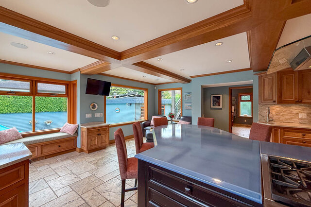 Spacious kitchen with granite countertops, wooden cabinetry, and a view of the backyard. - 3850 Point Grey Road, Vancouver West Side