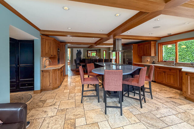 Spacious kitchen with wooden cabinets, granite countertops, and a large island. - 3850 Point Grey Road, Vancouver West Side