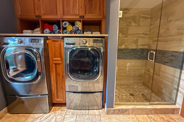 Spacious laundry room with granite countertops and wooden cabinets. - 3850 Point Grey Road, Vancouver West Side