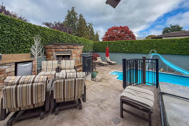 Spacious patio with outdoor fireplace, lounge chairs, and a swimming pool. - 3850 Point Grey Road, Vancouver West Side