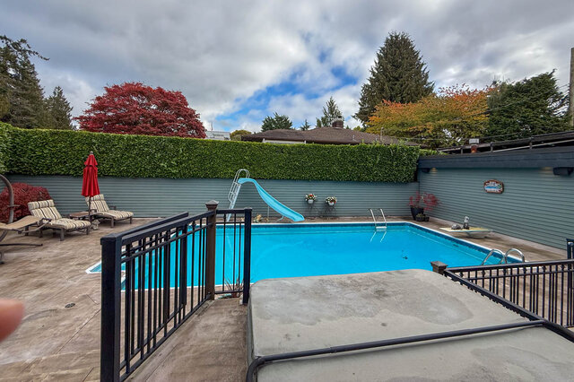 Spacious backyard with a swimming pool, slide, and patio furniture. - 3850 Point Grey Road, Vancouver West Side