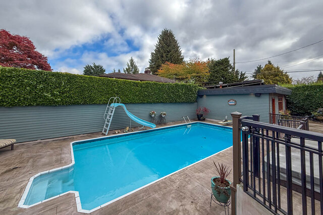 Spacious backyard with a large pool, slide, and privacy hedge. - 3850 Point Grey Road, Vancouver West Side