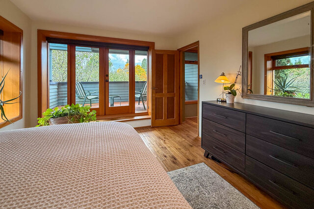 Spacious bedroom with hardwood floors, large windows, and a cozy dresser. - 3850 Point Grey Road, Vancouver West Side