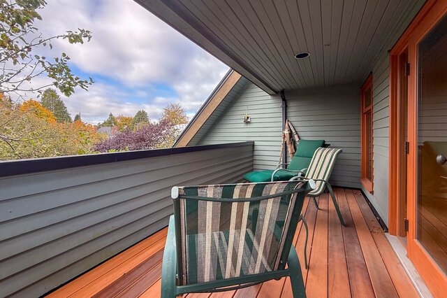 Cozy balcony with striped lounge chairs and a view of autumn foliage. - 3850 Point Grey Road, Vancouver West Side