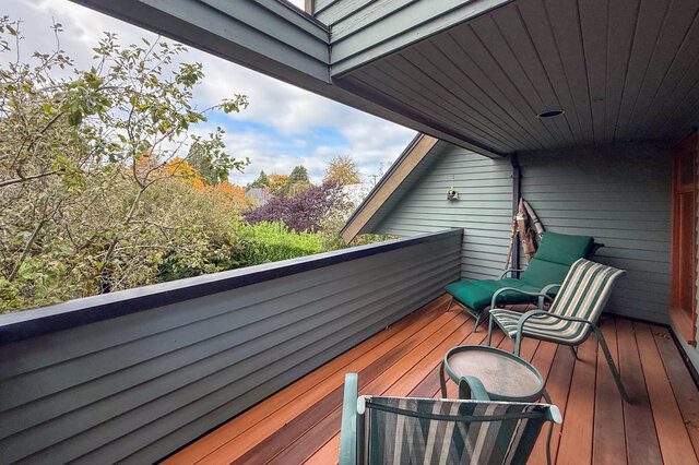 Spacious deck with wooden flooring, outdoor furniture, and a view of autumn foliage. - 3850 Point Grey Road, Vancouver West Side