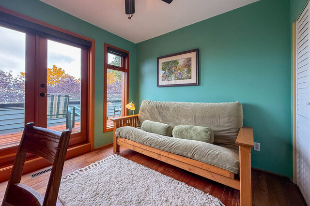 Spacious living room with teal walls, wooden furniture, and a view of the garden. - 3850 Point Grey Road, Vancouver West Side