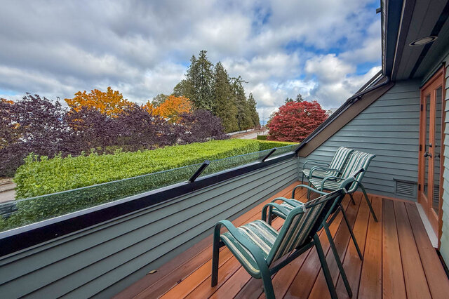Spacious deck with wooden flooring, outdoor chairs, and a view of autumn foliage. - 3850 Point Grey Road, Vancouver West Side