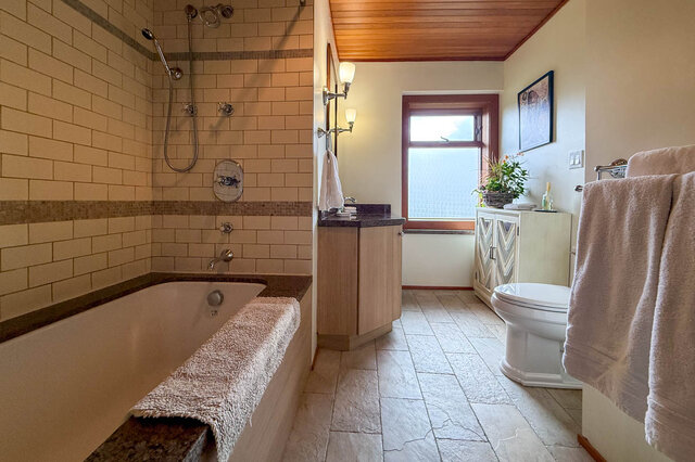 Spacious bathroom with granite countertops, wooden ceiling, and a large window. - 3850 Point Grey Road, Vancouver West Side
