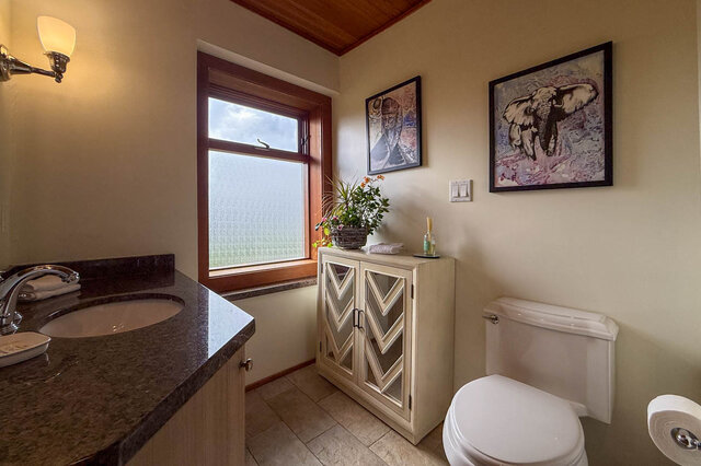 Spacious bathroom with granite countertops, wooden cabinets, and a large window. - 3850 Point Grey Road, Vancouver West Side