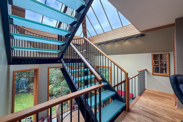 Spacious living room with a modern glass staircase and large skylight, perfect for natural light. - 3850 Point Grey Road, Vancouver West Side