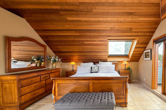 Spacious bedroom with wooden ceiling, large mirror, and cozy seating area. - 3850 Point Grey Road, Vancouver West Side