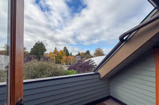 Bright balcony with a view of colorful trees and a partly cloudy sky. - 3850 Point Grey Road, Vancouver West Side