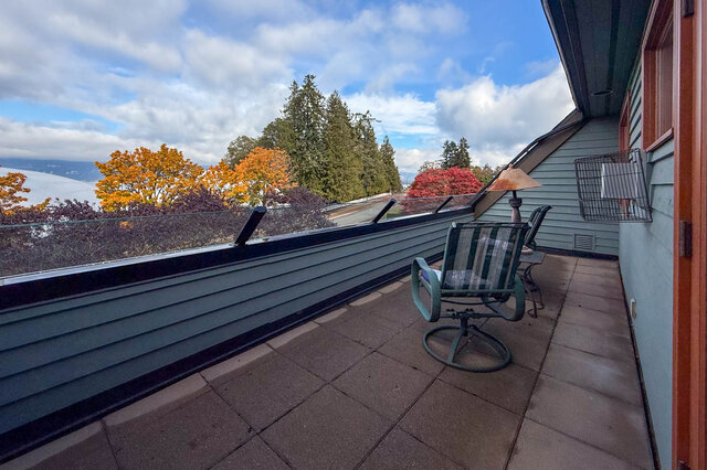 Bright patio with glass railing, colorful fall foliage, and a cozy corner with a lamp and chairs. - 3850 Point Grey Road, Vancouver West Side