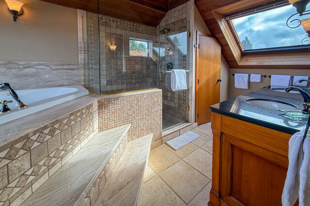 Spacious bathroom with a large soaking tub, glass-enclosed shower, and a skylight offering natural light. - 3850 Point Grey Road, Vancouver West Side