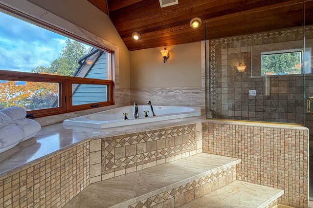 Spacious bathroom with a large soaking tub, mosaic tile accents, and a view of the outdoors. - 3850 Point Grey Road, Vancouver West Side