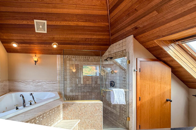 Spacious bathroom with wooden ceiling, marble tub, and glass shower enclosure. - 3850 Point Grey Road, Vancouver West Side
