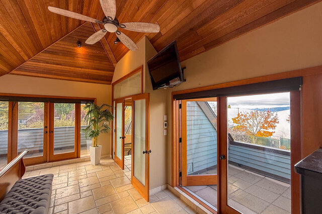 Spacious living room with wooden ceiling, large sliding doors, and stunning city view. - 3850 Point Grey Road, Vancouver West Side